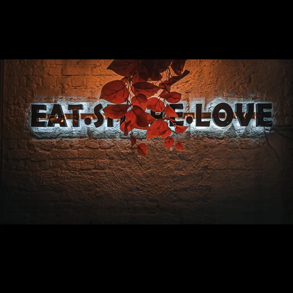 Eat, style, love — a neon sign and a few red leaves did the styling.